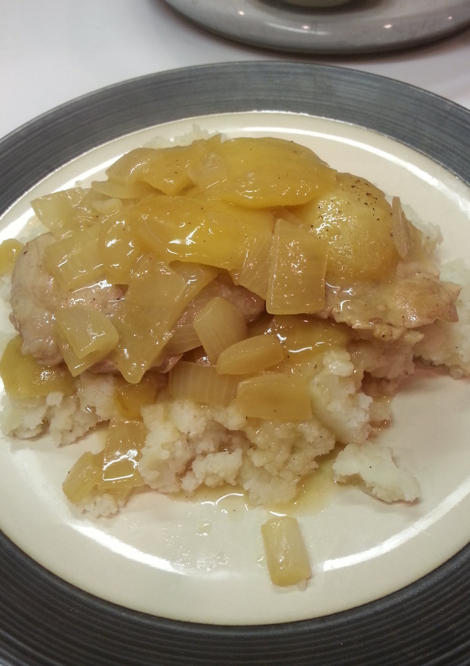 A picture of Pork chops with caramelized apple and onion.