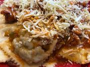 Una foto de raviolis de carne con queso