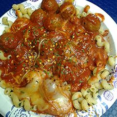 A picture of Cheesy corkscrews with meatballs.