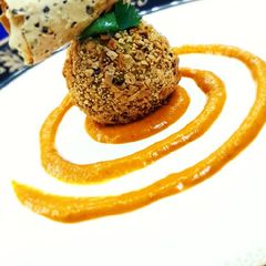 A picture of Dal chawal arancini with makhani gravy.