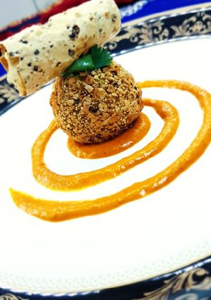 A picture of Dal chawal arancini with makhani gravy.