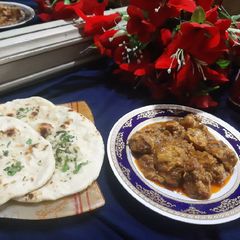 A picture of Chicken masala with tawa garlic naan.