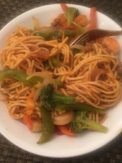 A picture of Spaghetti with green pepper and carrots.