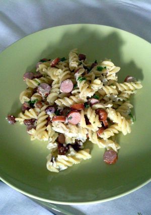 A picture of HotDog Sausages with Penne and Sultanas.