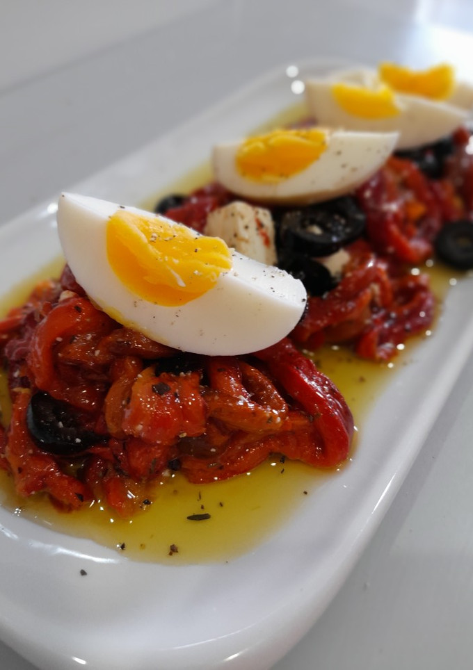 Una foto de Pimientos asados con queso feta, olivas negras y huevo duro