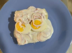 Una foto de Yuca cocida + huevo cocido en salsa de suero costeño y cebollas