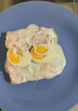 Una foto de Yuca cocida + huevo cocido en salsa de suero costeño y cebollas