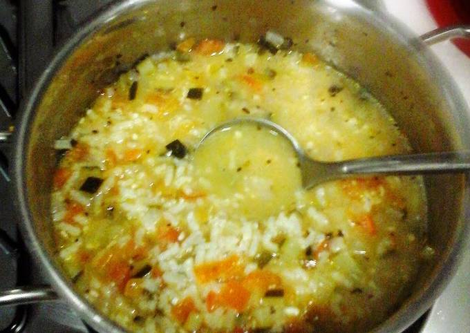 Risotto rice soup with green zucchini and tomato