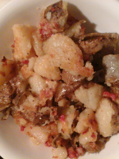 A picture of Fried potatoes with bacon.