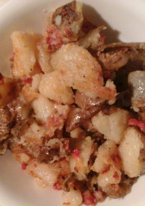 A picture of Fried potatoes with bacon.