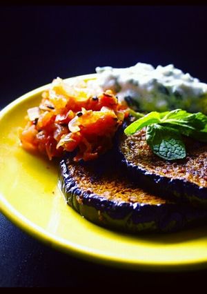 A picture of grilled eggplant with yoghurt n tomato dip.