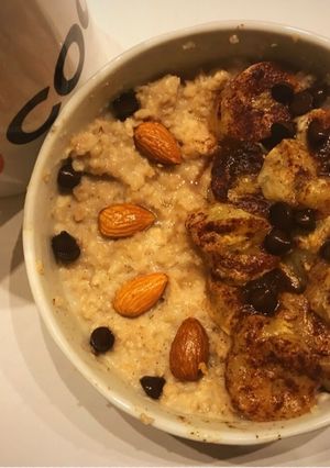 Una foto de Porridge de avena con banana caramelizada, chips de chocolate y almendras, desayuno rápido saludable