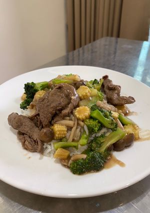 A picture of Beef in gravy sauce over rice.