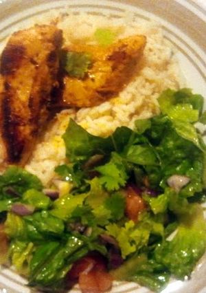A picture of Middle-eastern Spiced chicken with rice and middle-eastern salad.