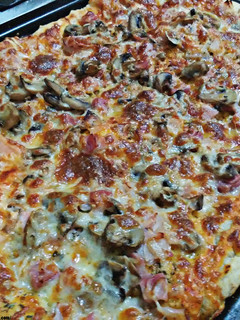 Una foto de Pizza casera de bacon y champiñones