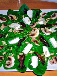 Una foto de Ensalada con champiñones, espinaca baby, tomates secos, queso fresco y piñones