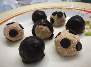 Una foto de Trufas de coco rallado y leche condensada rellenas de nuez bañadas en chocolate