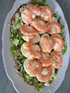 Una foto de Huevos rellenos de langostinos con cama de lechuga balsámica
