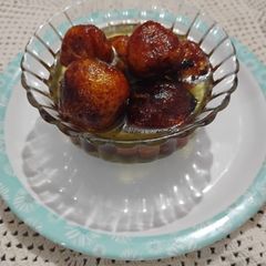 A picture of Dryfruit stuffed Gulab Jamun with Jaggery Syrup.
