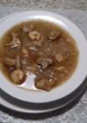 A picture of Chicken soup with Rice vermicelli, shrimp, and mushrooms.