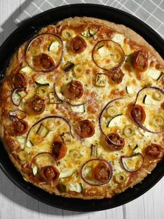 Una foto de Pizza integral en panificadora con verduritas y queso