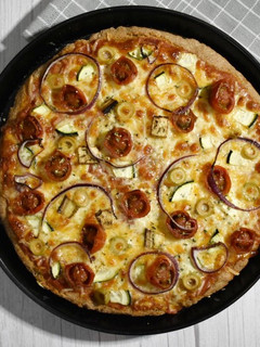 Una foto de Pizza integral en panificadora con verduritas y queso