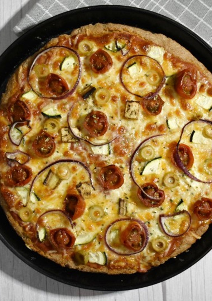 Una foto de Pizza integral en panificadora con verduritas y queso