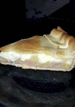 Una foto de Tarta de cebolla, papas, jamón y queso