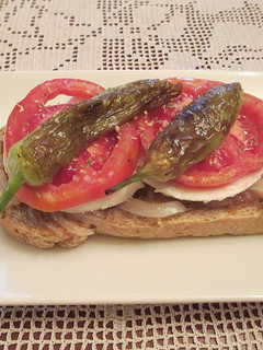Una foto de Tapas - Cebolla caramelizada con queso fresco tradicional, tomates Rosa Extremeño y mini pimientos italianos fritos