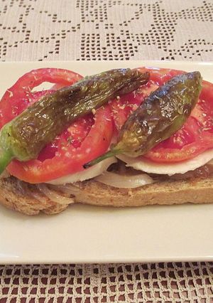 Una foto de Tapas - Cebolla caramelizada con queso fresco tradicional, tomates Rosa Extremeño y mini pimientos italianos fritos