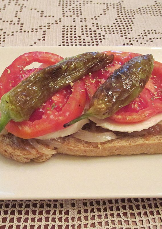 Una foto de Tapas - Cebolla caramelizada con queso fresco tradicional, tomates Rosa Extremeño y mini pimientos italianos fritos