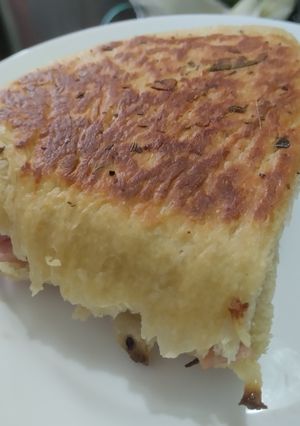 Una foto de Sándwich🥪de salchichón de cerdo🥓y queso🧀en pan🍞casero de ajo🍖y finas hierbas🥐🌿🧄