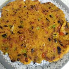 A picture of Makke ki roti with green garlic leaves.