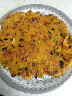 A picture of Makke ki roti with green garlic leaves.