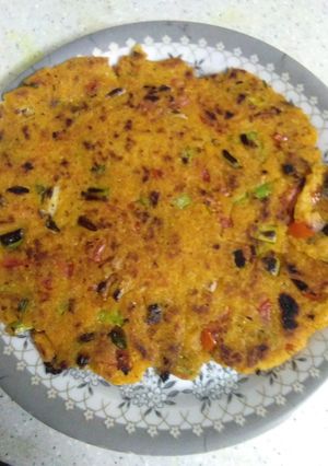 A picture of Makke ki roti with green garlic leaves.