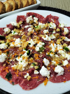 Una foto de Carpaccio de ternera con queso de cabra y aliño de naranja y miel