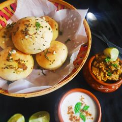 A picture of Awadhi Murg Stuffed Garlic Naan buns with Bhurani Raita.