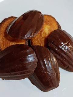 Una foto de Madeleines sin gluten de vainilla con cobertura de chocolate