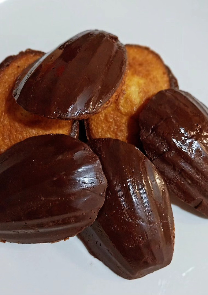 Una foto de Madeleines sin gluten de vainilla con cobertura de chocolate
