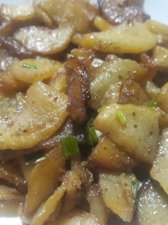 A picture of Fried potatoes with spring onion.