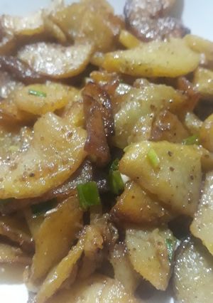 A picture of Fried potatoes with spring onion.