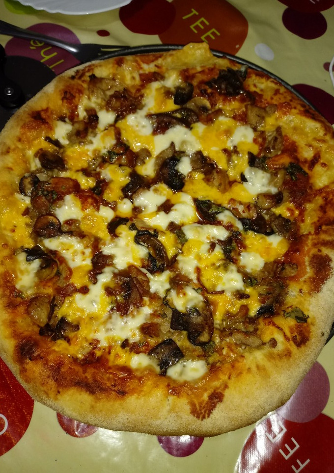 Una foto de Pizza de pollo champiñones y berenjenas con los bordes rellenos
