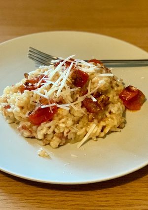 A picture of Oven baked risotto with bacon and tomatoes.