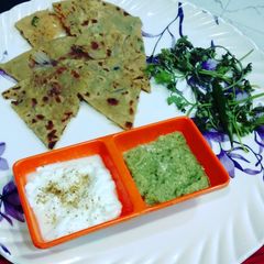 A picture of Pyaj ka paratha with curd or green chutney.