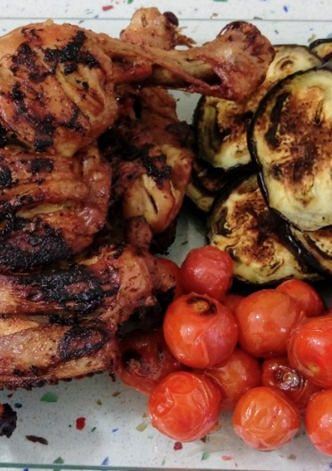 Una foto de Muslos de pollo frito con berenjenas y tomatitos cherry asados