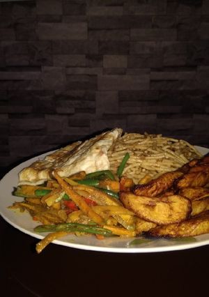 A picture of Omelette, pasta, veggies and fried plantain.