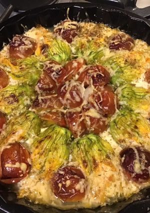Une photo de Fleurs de courgettes farcies aux crevettes tomates cerises noires et deux fromages