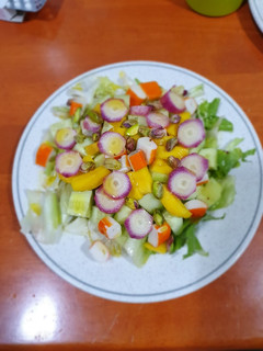 Una foto de Ensalada de cangrejo, mango y pistachos