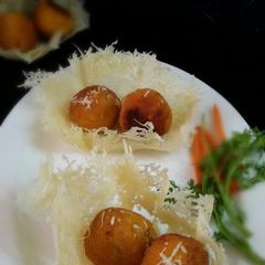 A picture of Mozzarella Stuffed Cottage Cheese Balls Served In Parmasean Cheese Basket.