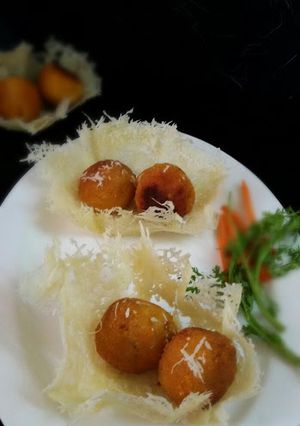 A picture of Mozzarella Stuffed Cottage Cheese Balls Served In Parmasean Cheese Basket.